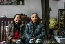 Older couple sitting in front of a cup of tea