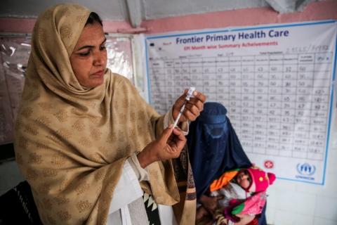 3 January 2018: A health worker, Majra Bibi, prepares to vaccinate a four-month-old baby in a primary health care centre in Nowshera District, Khyber Pakhtunkhwa province, Pakistan.