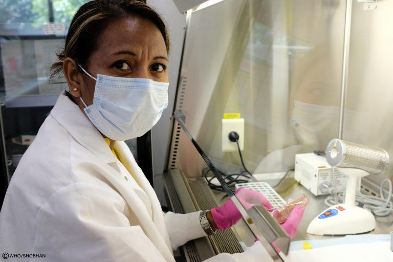 A lab technician working at the National Health Laboratory on the PCR workstation donated by WHO.